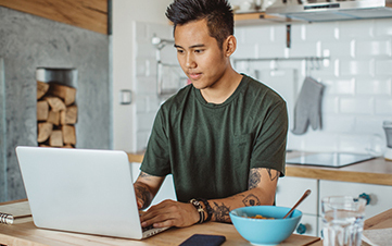 Young male sitting at a desk while on his laptop