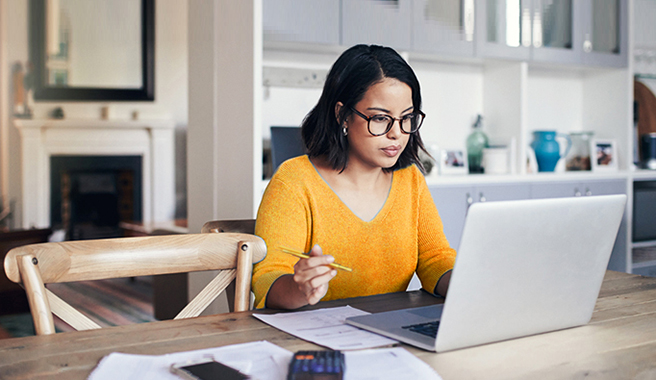 woman on laptop taking notes