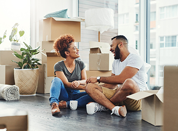 young man and woman surrounded by moving boxes