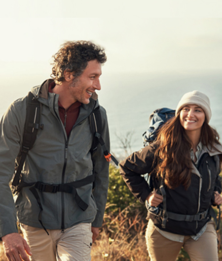 couple going for a hike up the mountain, near water at sunrise
