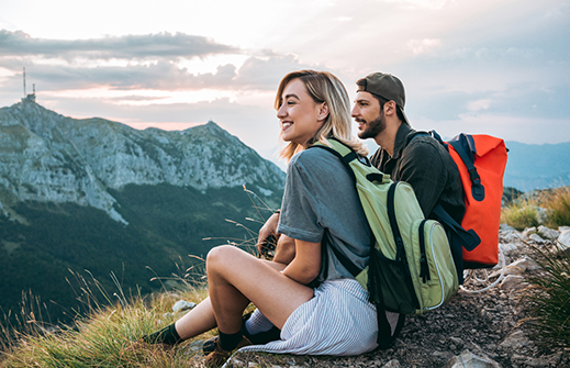 Young couple taking a break while hiking in the mountains