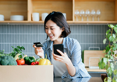 woman using her credit card and phone to pay for groceries