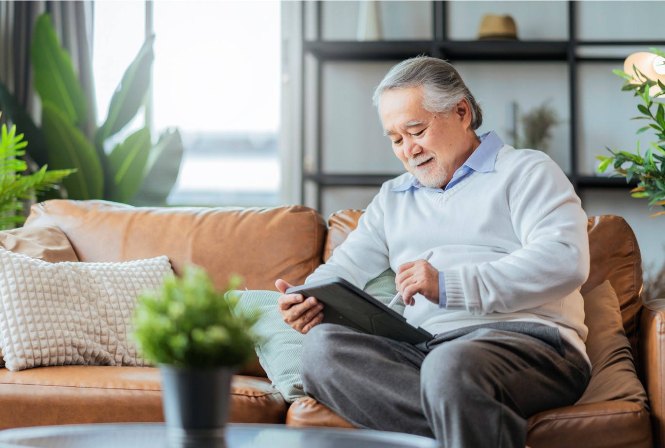 Older Chinese man sitting on a couch