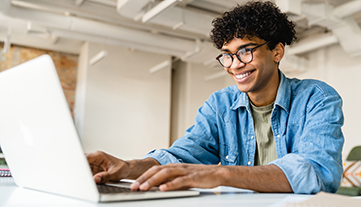 young man on laptop smiling